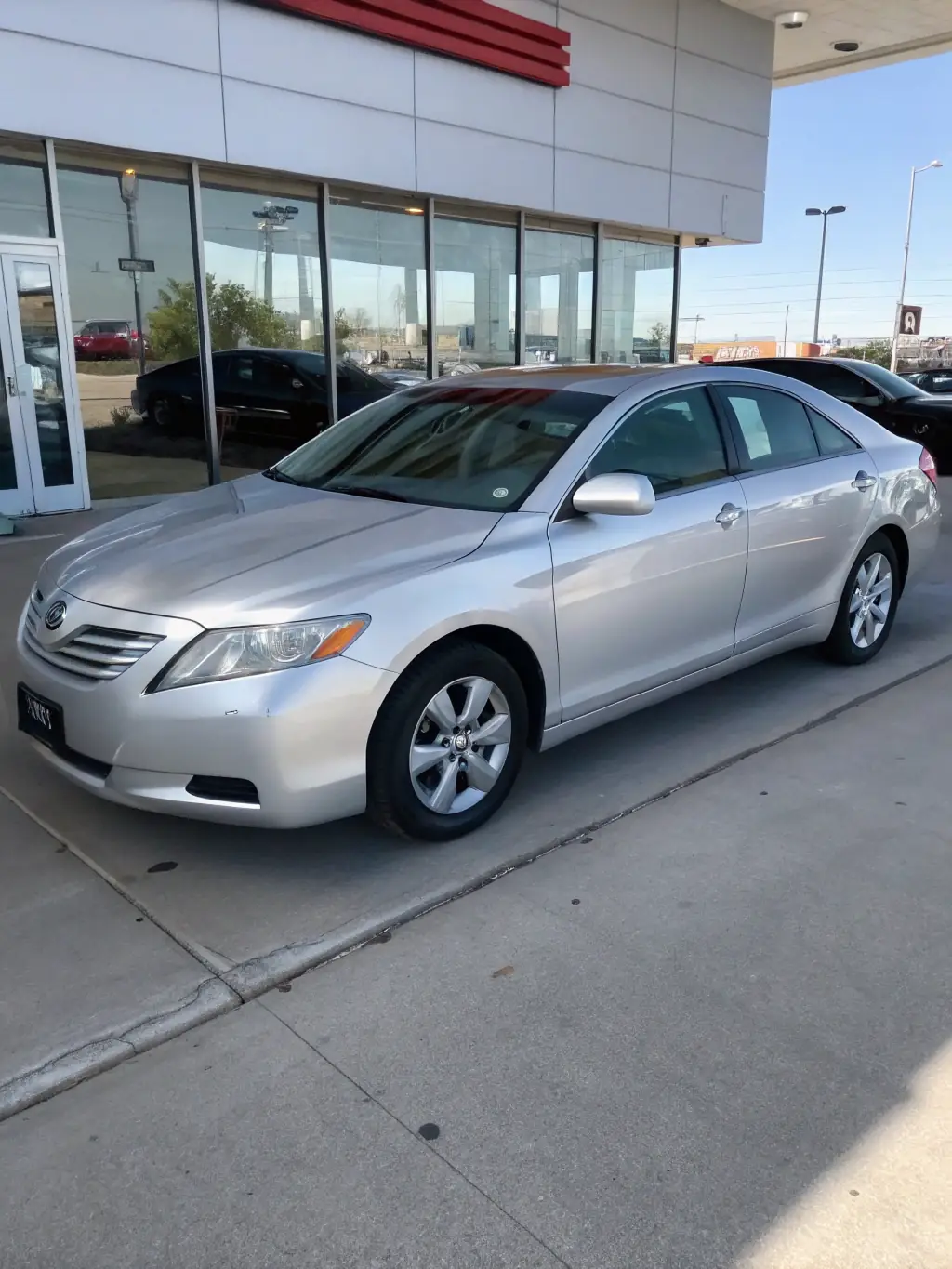 A silver Toyota Aqua parked in a well-lit showroom, showcasing its compact design and fuel efficiency, ideal for city driving in Cyprus.
